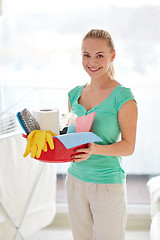 Image showing happy woman holding cleaning stuff at home