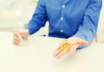 Image showing close up of male hand showing lot of pills