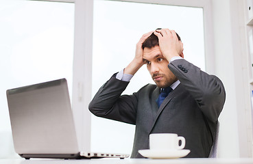 Image showing businessman with laptop typing in office