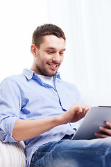 Image showing smiling man with tablet pc and cup at home