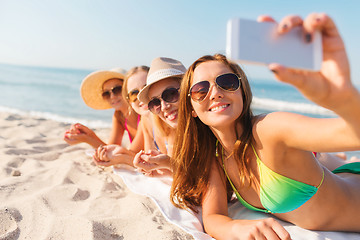 Image showing group of smiling women with smartphone on beach