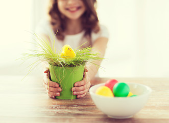 Image showing close up of girl holding pot with green grass