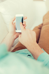 Image showing close up of man sitting with smartphone at home