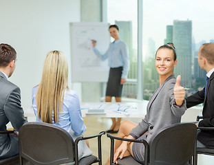 Image showing businesswoman with team showing thumbs up
