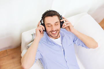 Image showing smiling young man in headphones at home