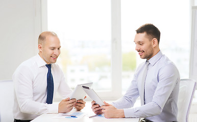 Image showing two smiling businessmen with tablet pc in office