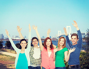 Image showing group of smiling students waving hands