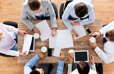 Image showing close up of business team with coffee and papers