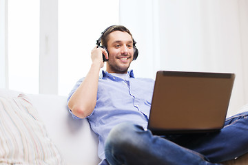 Image showing smiling man with laptop and headphones at home