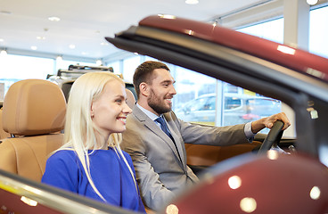 Image showing happy couple sitting in car at auto show or salon