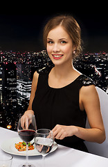 Image showing smiling young woman eating main course