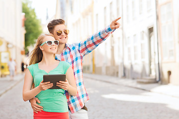 Image showing smiling couple with tablet pc in city