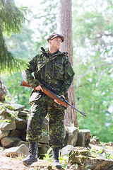 Image showing young soldier or hunter with gun in forest