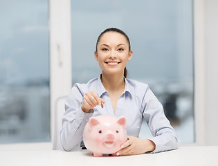 Image showing smiling woman with piggy bank and cash money