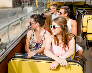 Image showing group of smiling friends traveling by tour bus