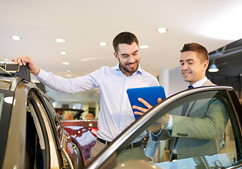 Image showing happy man with car dealer in auto show or salon