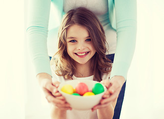 Image showing smiling girl and mother holding colored eggs