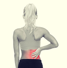 Image showing sporty woman touching her back