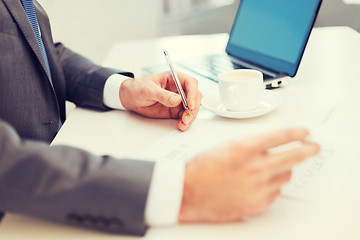 Image showing man hands with contract and pen, coffee and laptop