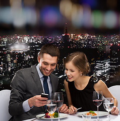 Image showing smiling couple eating main course at restaurant