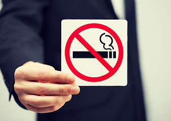 Image showing man in suit holding no smoking sign