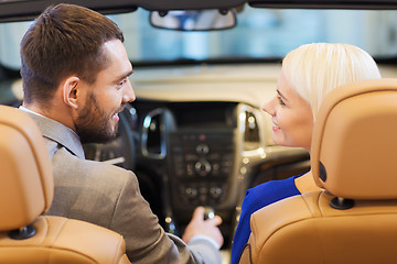 Image showing happy couple sitting in car at auto show or salon