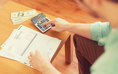 Image showing close up of man counting money and making notes