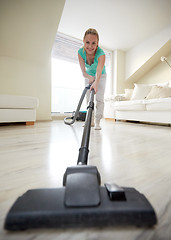 Image showing happy woman with vacuum cleaner at home