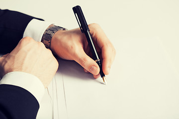 Image showing businessman writing something on the paper