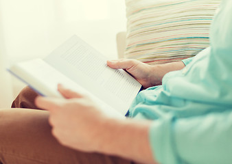 Image showing close up of man reading book at home