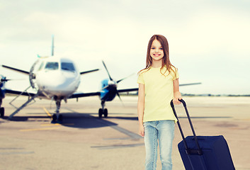 Image showing smiling girl with travel bag in airport