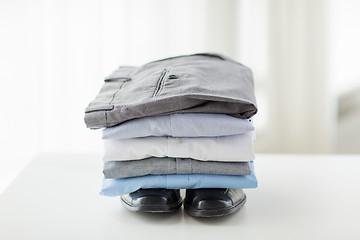 Image showing close up of male shirts, pants and shoes on table