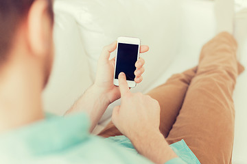 Image showing close up of man sitting with smartphone at home