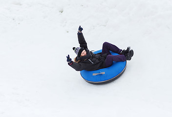 Image showing happy young man sliding down on snow tube