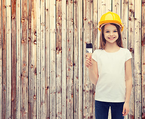 Image showing smiling little girl in helmet with paint roller