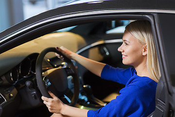 Image showing happy woman inside car in auto show or salon