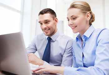 Image showing smiling businesspeople with tablet pc in office