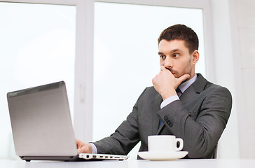 Image showing businessman with laptop typing in office