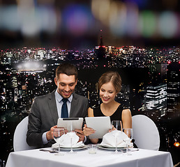 Image showing couple with menus on tablet pc at restaurant