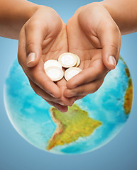 Image showing cupped hands holding euro coins over earth globe