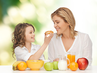 Image showing happy mother and daughter eating breakfast