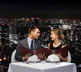 Image showing smiling couple with menus at restaurant