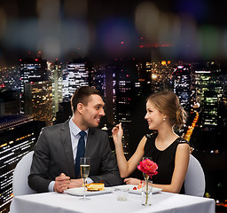 Image showing smiling couple eating dessert at restaurant