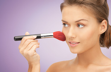 Image showing close up of young woman with makeup brush