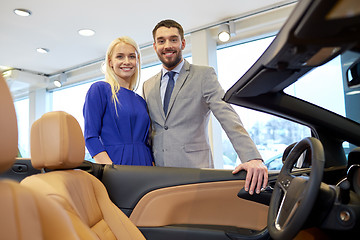 Image showing happy couple buying car in auto show or salon