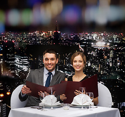 Image showing smiling couple with menus at restaurant