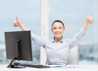 Image showing woman with computer, papers showing thumbs up