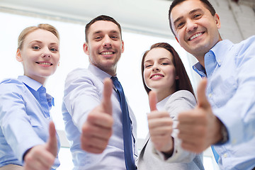 Image showing smiling business people showing thumbs up