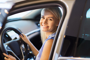 Image showing happy woman inside car in auto show or salon