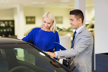 Image showing happy woman with car dealer in auto show or salon